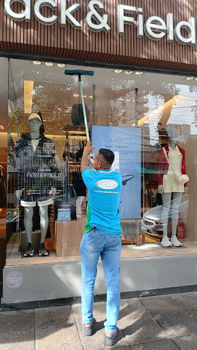 Homem limpando vitrine de loja